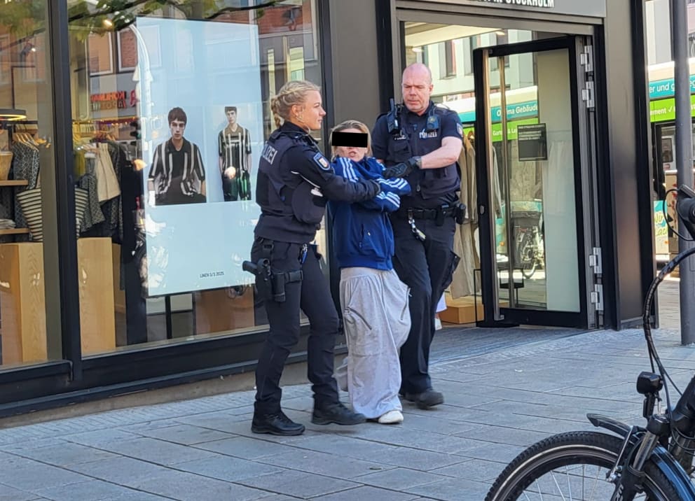 Eine Polizistin und ein Kollege führen die 37-Jährige ab