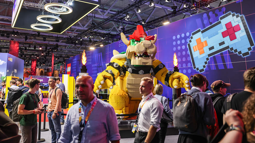 Fachbesucher werfen einen Blick auf den Messestand der Firma Lego