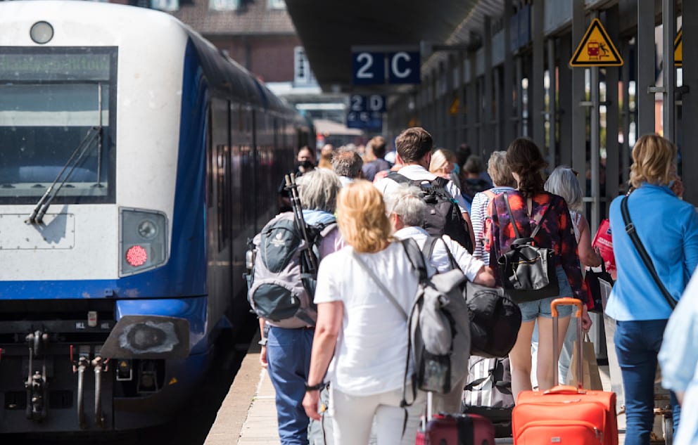 Reisende auf dem Bahnhof Westerland auf Sylt. Links ein Zug der Marschbahn