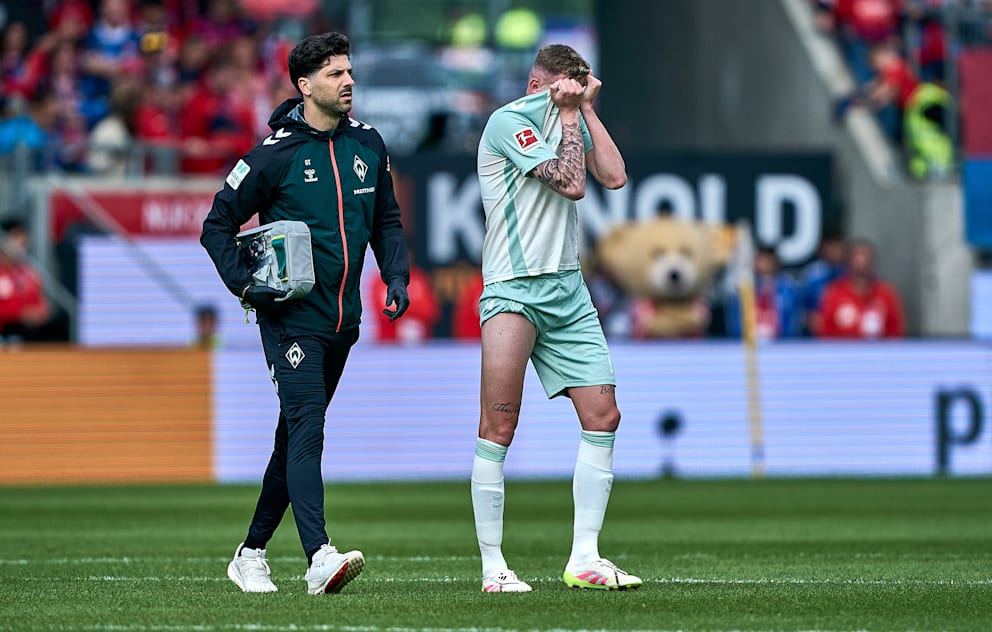 Marvin Ducksch (30/rechts) schreitet unter Schmerzen mit Team-Doc Georg Tsironis vom Platz