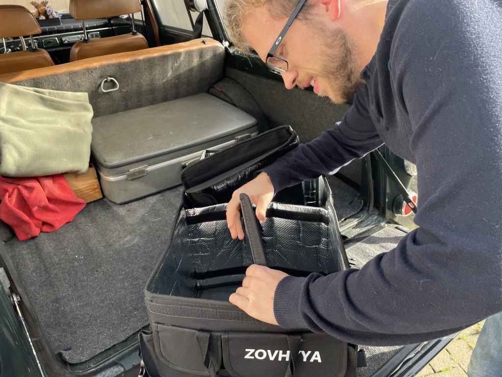 Redakteur setzt in einem Kofferraum einen Kofferraum-Organizer zusammen.