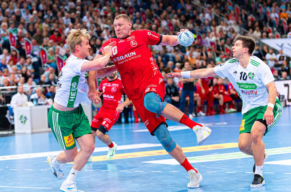 Marian Michalczik (l.) und Renars Uscins (r.) können Melsungens Dainis Kristopans nicht stoppen