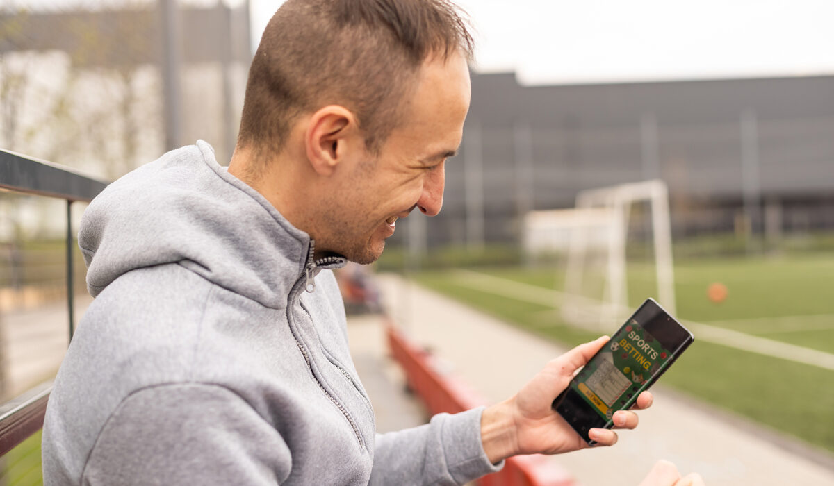 Mann benutzt App auf Tribüne