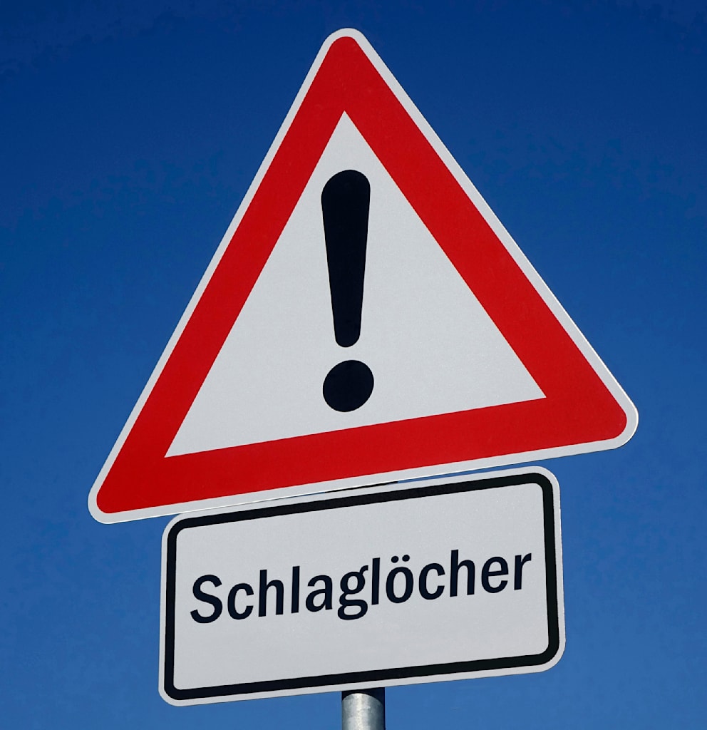 Achten Sie unbedingt auf Warnschilder, die auf Straßenschäden hinweisen