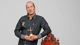 Peter Fitzek 2012 im roten Mantel mit Hermelin-Pelz. Er hält einen Säbel in der Hand, die Krone liegt hinter ihn