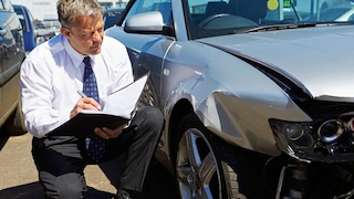 Loss Adjuster Inspecting Car Involved In Accident