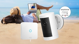 Mann sitzt auf Liegestuhl an einem Strand. Im Vordergrund sieht man eine Kamera und Intercom von Ring.