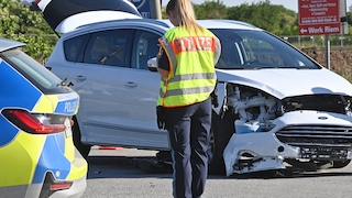 Polizistin bei der Unfallaufnahme nach Verkehrsunfall.